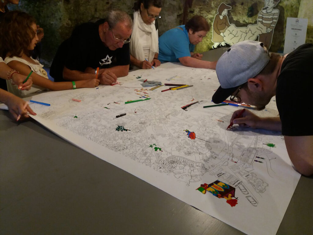 mappa in bianco e nero con persone che la colorano nel Porto Museo Tricase mappa di comunità